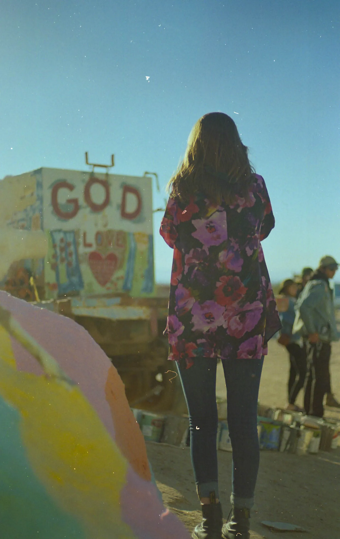 A visitor facing a painted folk-art monument.