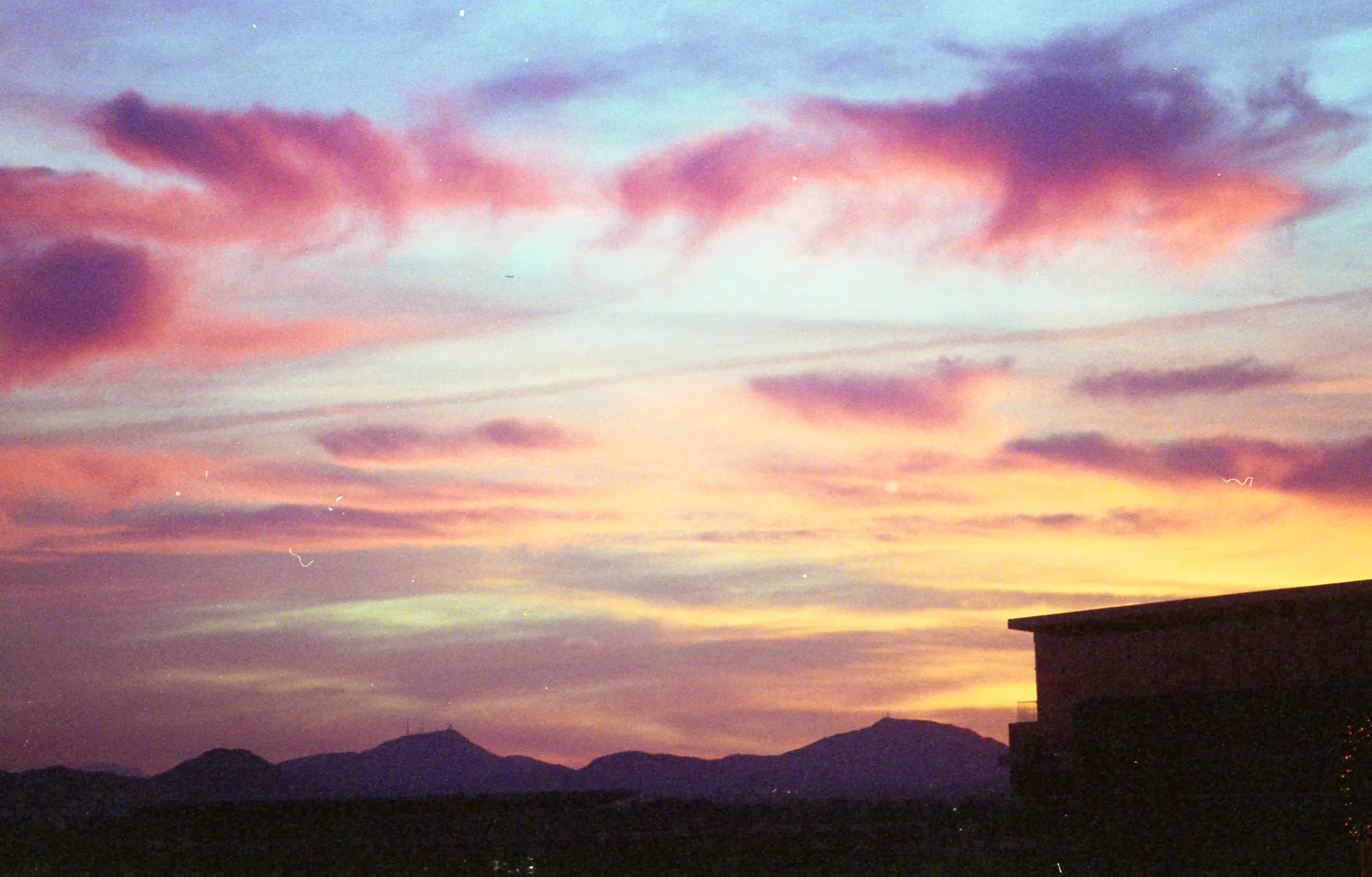 Mountain silhouettes under a pink and violet sky.