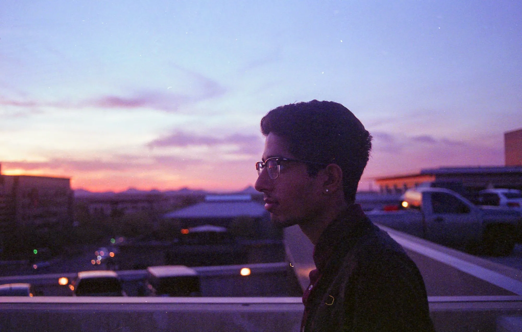 Rooftop profile beneath a violet sunset.