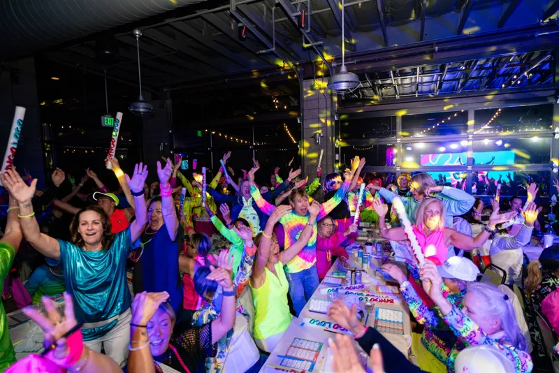 A packed Bingo Loco crowd cheering under colored light