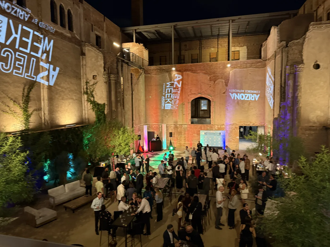 An evening AZ Tech Week event in a lit brick courtyard, produced by SPRK